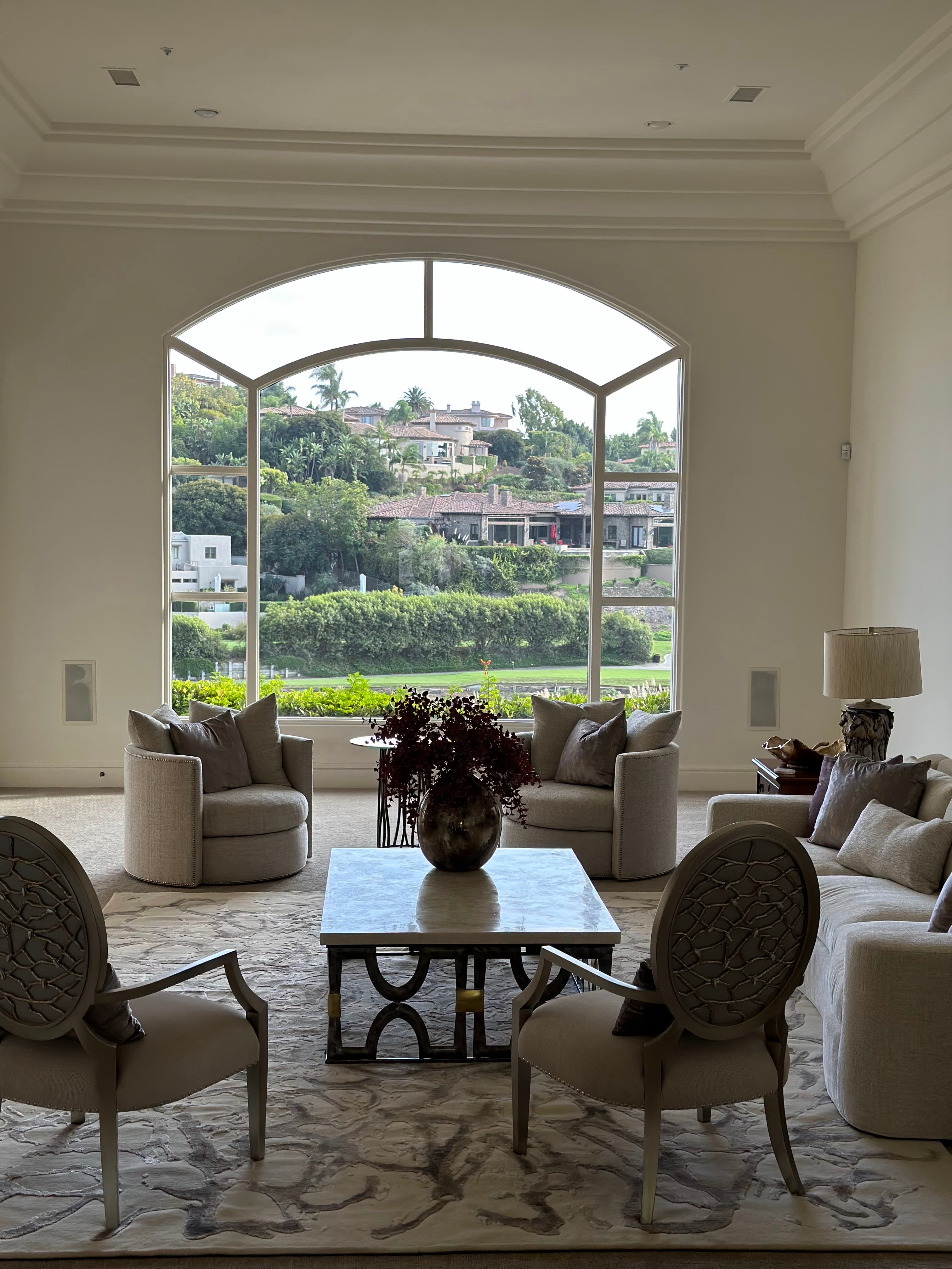 Grand living room with arched window and Oriental rug by Aja Rugs